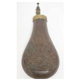 1060	ANTIQUE BRASS POWDER FLASK W/EMBOSSED CANON, GUNS, & FLAGS, APPROXIMATELY 8 IN HIGH