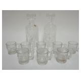 1124	PAIR OF WATERFORD CRYSTAL DECANTORS AND 8 ANTIQUE EMBOSSED CHILDS MUGS WITH IMAGES OF DOGS AND 