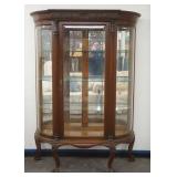 1230	ORNATE OAK CHINA CABINET WITH BEVELED GLASS DOOR AND CURVED SIDES, HAVING A SHELL CARVED CREST 