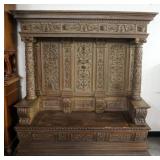 1235	HEAVILY CARED HOODED CONTINENTIAL HALL BENCH WITH LIFT TOP SEAT. CARVED ALL OVER COLUMNS AND PA
