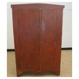 1184	PRIMITIVE 2 DOOR PINE CUPBOARD WITH SCALLOPED EDGE BASE IN RED PAINT FINISH, APPROXIMATELY 42 I