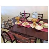 Silver and china displayed on Duncan Phyfe table and chairs