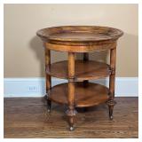GUERIDON TABLE Four turned wood legs on casters, three tiers, top surface has framed lip edge; h. 27