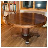 ROUND WOOD TABLE | Round topped table supported by a central column attached to a base with feet on 