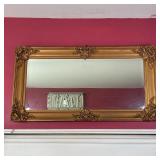GILT WALL MIRROR | With scrollwork accents and beveled glass; 25 x 47 in. 