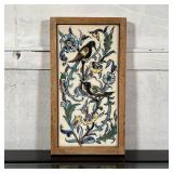 PAINTED TILE | Showing birds upon flowering branches, set in a wood frame; overall 9 x 5 in. 