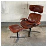 EAMES STYLE LEATHER CHAIR & OTTOMAN | By Selig Manufacturing, having saddle brown leather upholstery