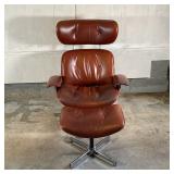 EAMES STYLE LEATHER CHAIR & OTTOMAN | By Selig Manufacturing, having saddle brown leather upholstery