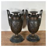 PAIR BRONZE URNS | Heavy and solid, with flower and leaf design to body with leafy scrollwork handle