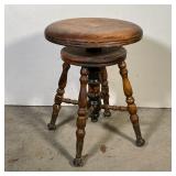 ANTIQUE WOOD STOOL | Round seat swiveling seat over turned wood legs and stretcher with iron-capped 