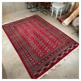 BOKHARA CARPET | 20th century hand woven wool rug, having a red field and red borders, having rich c