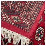 BOKHARA CARPET | 20th century hand woven wool rug, having a red field and red borders, rich colors