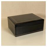 NAT SHERMAN HUMIDOR | Black leather with gilt tooled decorative borders; h. 4 x w. 10-1/2 x d. 8 in.