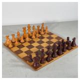 CARVED WOOD CHESS SET | Board with leather bottom marked "Made in Italy", with carved wood game piec
