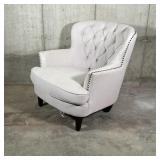 WINGED CLUB CHAIR | Cream colored fabric club chair with tufted backrest and tacked side accents...