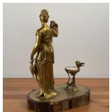 GILT METAL SCULPTURE | Robed figure with a bird upon her shoulder holding a ewer beside a bird bath 