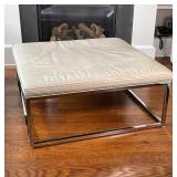 MITCHELL GOLD + BOB WILLIAMS LOW TABLE | Having a white leather wrapped cushioned top with chrome ta