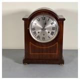 WOOD MANTEL CLOCK | Mantel clock with a round silvered face with Roman numerals, in a wood case with