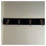 ANTIQUE MOUNTED COAT RACK | Four brass hooks mounted on a mahogany plank; 38-1/2 x 6 in.