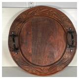 ROUND CARVED WOOD TRAY | With carved scrollwork border and two black painted metal handles; dia. 20 