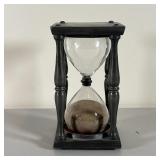 BLOWN GLASS HOURGLASS | In a chased pewter frame with velvet pads mounting the hourglass; h. 7 x 4 x