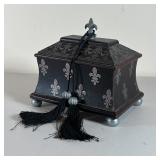 TOOLED LEATHER BOX | With overall fleur de lis decoration, lift top lid, with pewter feet and finial