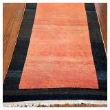 ANTIQUE RUNNER | Has a reddish field within a black-brown border, with abrash; l. 19 ft x 4ft 5 in