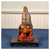 CHINESE HORN FIGURE | Carved horn figure with foo lion, on a flat wood stand; figure h. 6-1/4 in.