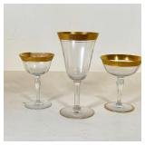 SET GILT STEMWARE | With goblets, sherry glasses, and cordial glasses, all with gilt scrollwork rims