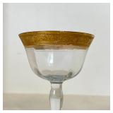 SET GILT STEMWARE | With goblets, sherry glasses, and cordial glasses, all with gilt scrollwork rims