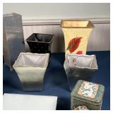 four tin boxes, two toleware planters, a pair of silvered planters, a metal vase, and three trivets