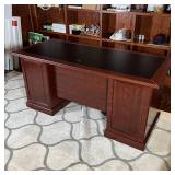 Cherry wood tone frame with two banks of drawers, having an inset writing surface; h. 30 x w. 64-3/4