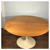 EERO SAARINEN TULIP TABLE | Tulip dining table with a wood top over a white base; h. 28-1/2 x dia. 5