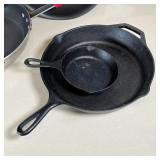 2 Lodge cast iron pans, a small egg pan, a large frying pan and a wok