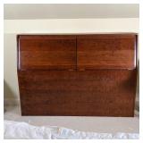 Bespoke headboard cabinet with two fold-down doors, interior with empty space and drilled for wiring