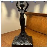 blue stained glass shade shaped like a willow tree, with a statue of a woman as the base, with depic