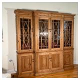 Beautiful natural wood finish, four glass paneled doors over four cabinets with interior shelves, wi
