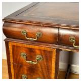 wood desk with inset leather top and gilt scroll work border over drawers with burl veneer; h. 30 x 