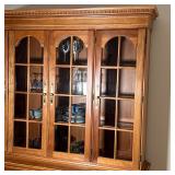  cherry four paneled glass doors revealing four shelves over four solid wood cabinet doors - middle 