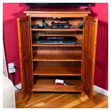 Small media / storage cabinet with two vertical slatted doors revealing 5 shelves over four block fe