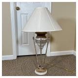 ITALIANATE TABLE LAMP | Designed as a small urn resting on four torch-form rods on a gilt base; over