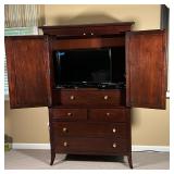 dresser cabinet with two checkered doors with contrasting woods opening to reveal a TV / entertainme