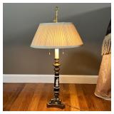 GREEK-STYLE TABLE LAMP | Brass tripod base supporting a black column with white raised laurel leaves