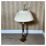 GREEK-STYLE TABLE LAMP | Brass tripod base supporting a black column with white raised laurel leaves