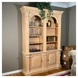 LIGHT WOOD WALL UNIT | Two section bookshelf cabinet having two banks of shelves over cabinet doors 