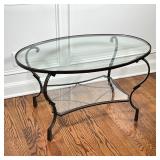 Low side table having a bronze-toned metal frame with an oval glass top and medial shelf; h. 20 x 36