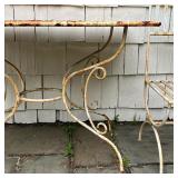 iron table with a scrollwork base and two chairs with demilune legs; table h. 33 x w. 48 x d. 28 in.