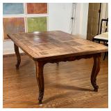 CUSTOM DINING TABLE | Old wood board top resting on a carved apron over cabriole legs, no apparent m