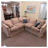 UPHOLSTERED SECTIONAL SOFA | In two sections, one with three seats the other with two, having beige 