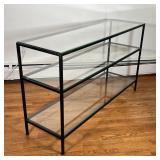 GLASS CONSOLE TABLE | Glass top with two lower glass shelves, on a black metal base; h. 33 x w. 56 x